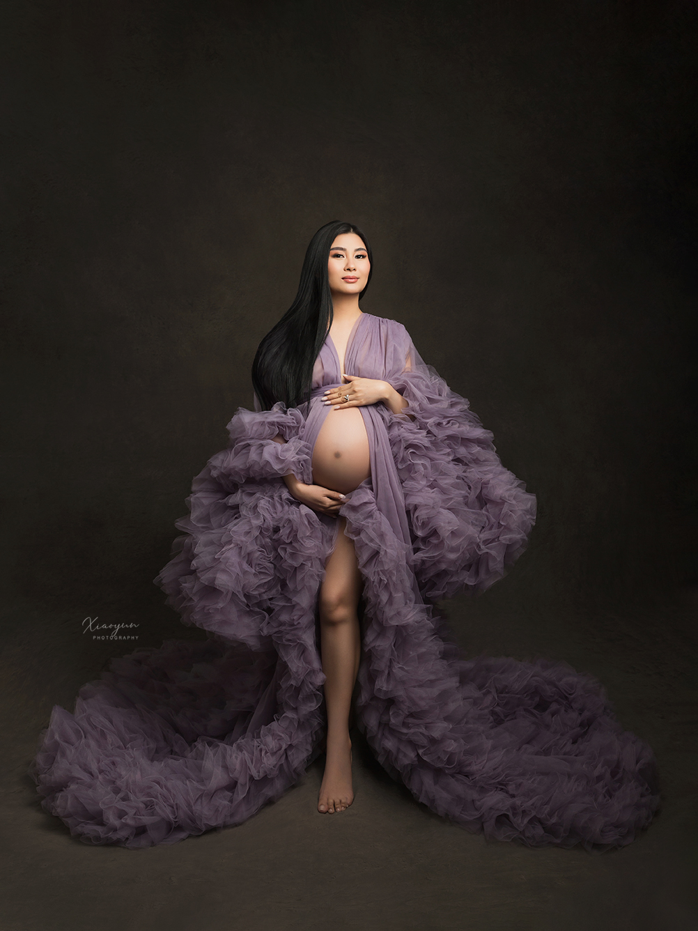 1s Fine art maternity portrait — pregnant woman in voluminous lavender tulle gown, studio setting with elegant and timeless style