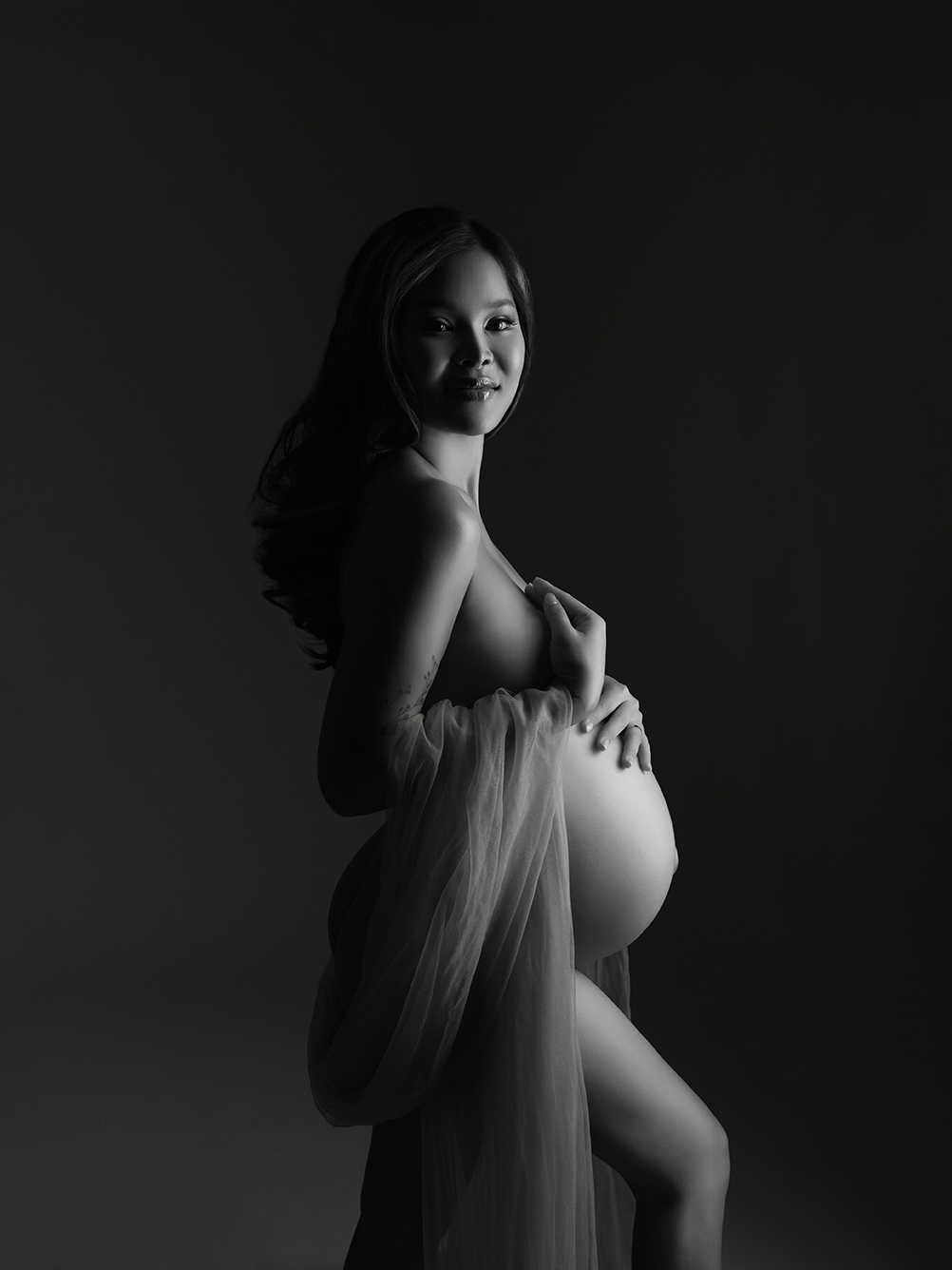 XIAOYUN PHOTOGRAPHY Artistic black and white maternity portrait of pregnant woman draped in sheer fabric, studio fine art nude style