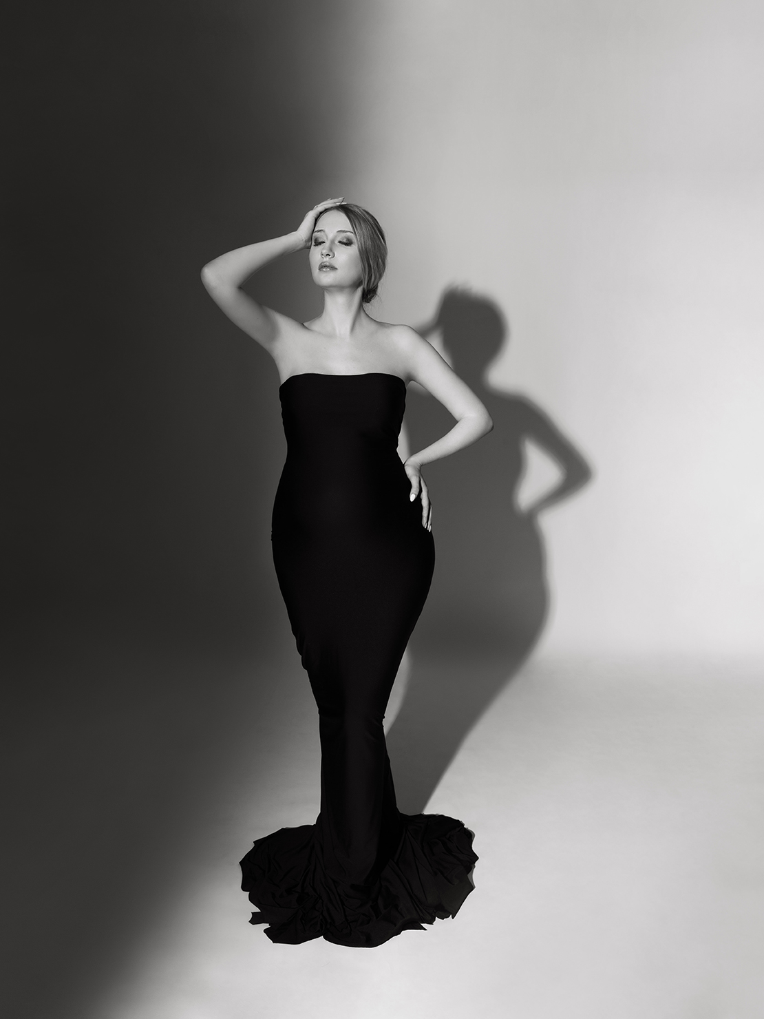 XIAOYUN PHOTOGRAPHY Black and white studio pregnancy shoot — pregnant woman in dramatic lighting with shadow play, high fashion style